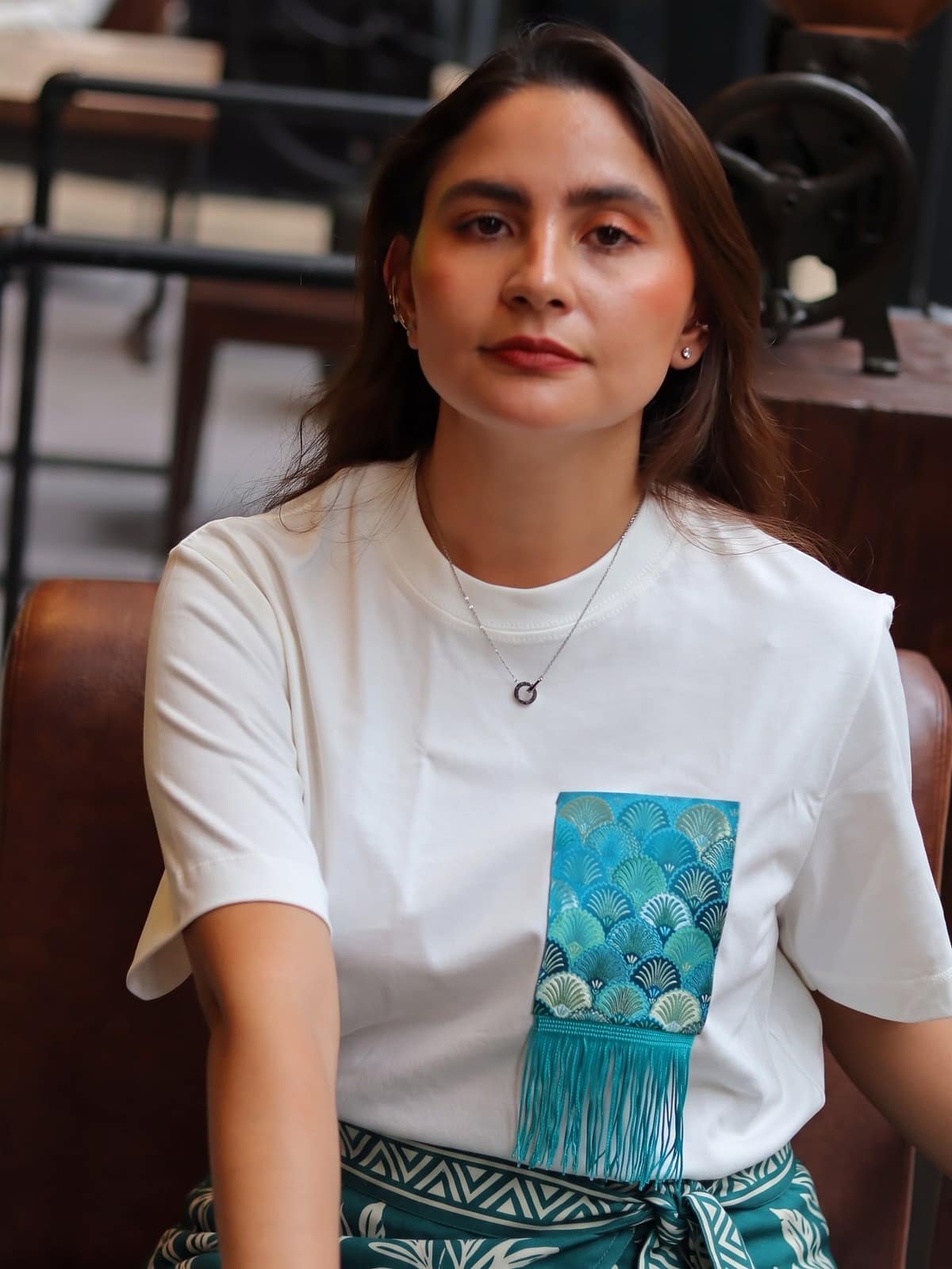 Camiseta de algodon blanco hueso con bolsillo de brocado de conchas turquesa
