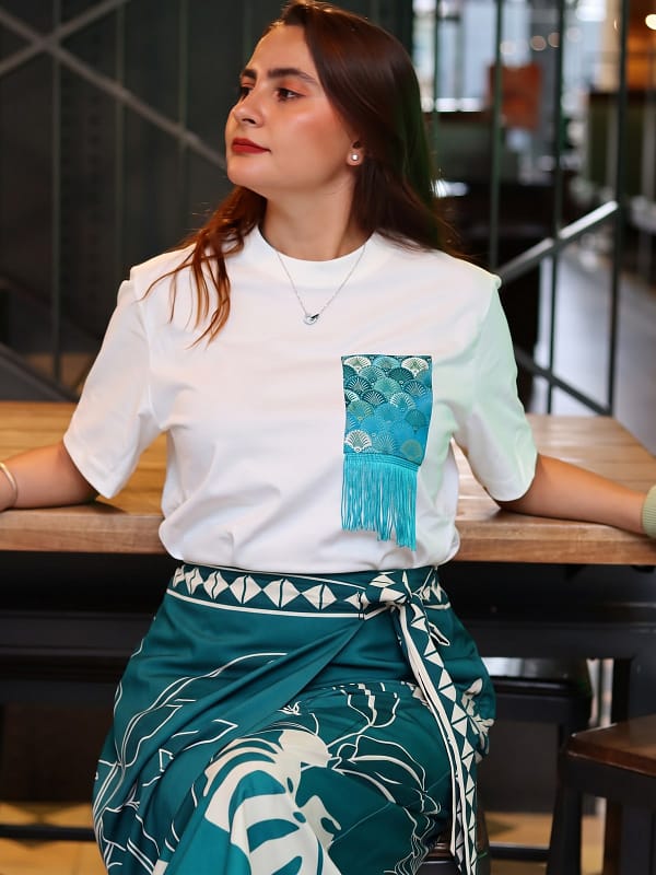 Camiseta blanco hueso con bolsillo de brocado de conchas turquesa y flecos turquesa